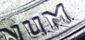 microscopic view of arrows noting doubling errors in unum on the reverse of a 2020 bat quarter of value