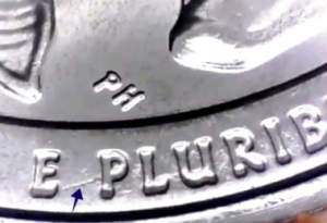 microscopic image of an arrow noting a die trail on the reverse of an american samoa quarter dollar between the letters E and P of E PLURIBUS