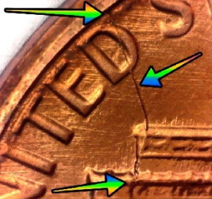 microscopic image of the reverse of a one cent 1983 of value featuring a large die crack from the d in united to the memorial building