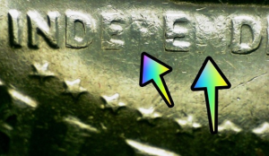 microscopic image with arrows pointing at a kennedy half dollar error coin