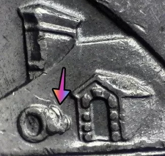 microscopic image of a 2017 ellis island new jersey quarter reverse displaying a die break shaped like a dog noted by an arrow