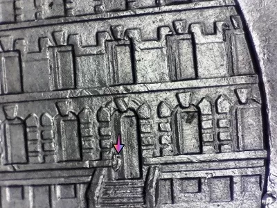 microscopic image of a 2017 ellis island new jersey quarter reverse displaying a die chip noted by an arrow
