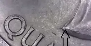 microscopic image of an arrow noting the error on a 2003 quarter obverse coin