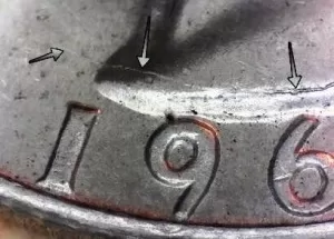 microscopic image of the 1964 date on the obverse of a silver quarter with arrows noting the die break on the error coin