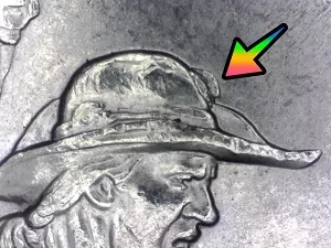 microscopic image of the reverse of a 2017 Indiana quarter with arrow noting error on the sailor hat