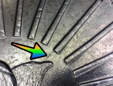 microscopic up close photo of the reverse of a maya angelou quarter with arrow noting bird twig die gouge error